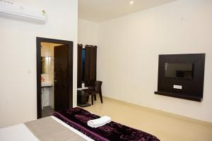 Habitación con cama y TV en la pared. en The Ashok Heritage Resort & Retreat, en Pushkar