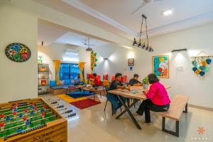 a group of people sitting at tables in a room at Zostel Pune (Viman Nagar) in Pune