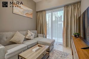 a living room with a couch and a large window at Mira Holiday Homes - Lovely 1 bedroom in Business Bay in Dubai