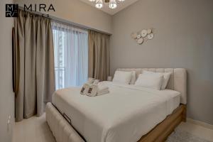 a large white bed in a room with a window at Mira Holiday Homes - Lovely 1 bedroom in Business Bay in Dubai