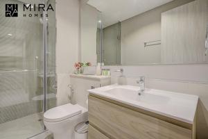 a bathroom with a sink and a toilet and a mirror at Mira Holiday Homes - Lovely 1 bedroom in Business Bay in Dubai