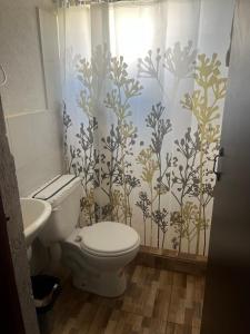 a bathroom with a toilet and a shower curtain at Casa de Campo en Zuleta in Huamboya