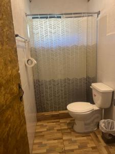 a bathroom with a toilet and a shower at Casa de Campo en Zuleta in Huamboya