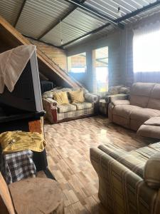 uma sala de estar com sofás e uma televisão de ecrã plano em Casa de Campo en Zuleta em Huamboya