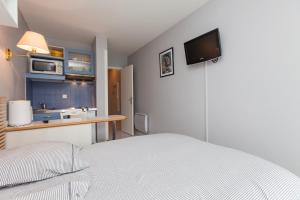 a bedroom with a bed and a kitchen with a sink at Résidence Le Crystal Dinard Plage in Dinard