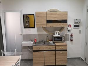 una piccola cucina con lavandino e forno a microonde di Dghajsa GUEST HOUSE a Senglea