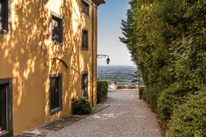 um beco que leva a um edifício com vista em Tenuta Guinigi Antico Borgo di Matraia - Exclusive Holidays apartments & Pool em Lucca