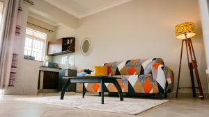 a living room with a couch and a table at Banana Bayou - Spacious Lake View Apt in Bunga, Netflix, 24hr Security in Kampala