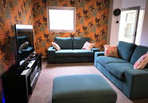 a living room with blue couches and a television at King on Sturt in Adelaide