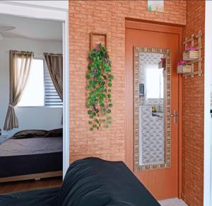 1 dormitorio con cama y pared de ladrillo en Apartamento Vista Linda - com suíte - Bertioga - Prox ao SESC, Riviera, Indaiá, en Bertioga