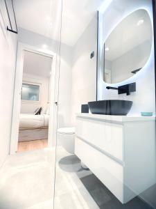 a white bathroom with a sink and a mirror at Nuevo Hola Madrid BIS in Madrid