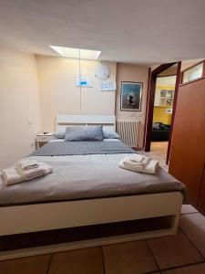 a bedroom with a large bed with two towels on it at Above The Sky - Flying Apartment in San Marino