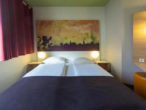 een slaapkamer met 2 bedden en een schilderij aan de muur bij B&B Hotel Weimar in Weimar