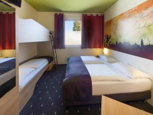 een hotelkamer met 2 bedden en een raam bij B&B Hotel Weimar in Weimar