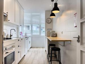 a kitchen with white cabinets and a counter with stools at Olaias Lisbon 2bed near Metro in Lisbon