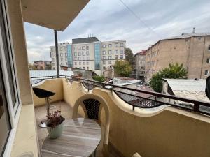 a balcony with a table and a view of buildings at Yerevan's Heart in Yerevan