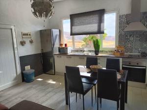 a kitchen with a table and chairs and a refrigerator at Casa Oasis in Teguise