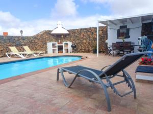 una silla sentada junto a una piscina en Casa Oasis, en Teguise