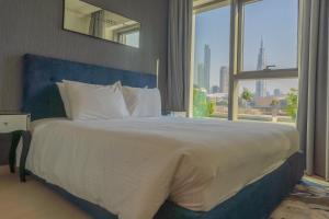 a bedroom with a large bed with a large window at BellaVista Chic 2 BR Downtown View II T1 - Burj Khalifa View in Dubai