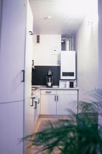 a kitchen with white cabinets and a coffee maker at Stadtwohnung mit Stadtpark Blick in Emden