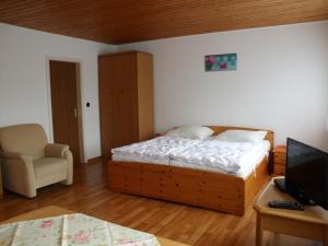 1 dormitorio con 1 cama, 1 silla y TV en Haus Hopp - Bungalow, en Dahme