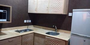uma cozinha com um lavatório e um frigorífico em درة رواق em Riyadh
