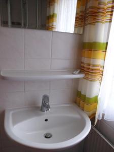 lavabo blanco en el baño con espejo en Haus Hopp - Bungalow, en Dahme