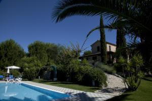 einen Pool vor einem Haus mit einer Palme in der Unterkunft Agriturismo Tenuta Sol Alto in Monsampolo del Tronto