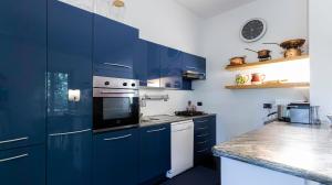 una cocina azul con electrodomésticos blancos y armarios azules en Italianway - Villa Visconta, en Briosco