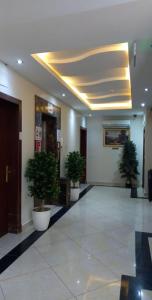 a hallway with three potted plants in a building at درة رواق in Riyadh +19 photos