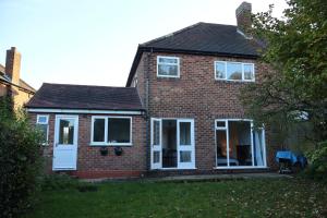 ein Backsteinhaus mit weißen Türen und Fenstern in der Unterkunft 4 bedroom cosy home in Solihull by airport Driveway for up to 3 cars perfect for contractors in Olton