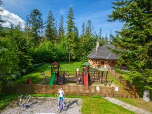 a park with a playground and a log cabin at Zespół Dolina Białego - Pensjonat Telimena in Zakopane