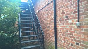 a spiral staircase next to a brick wall at The Grange Hotel in Bury Saint Edmunds
