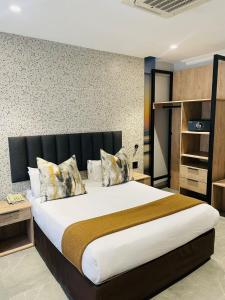 1 dormitorio con 1 cama grande y cabecero negro en Pavilion Hotel Durban en Durban
