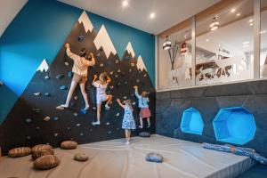 a room with a climbing wall and three children climbing on a wall at Zespół Dolina Białego - Pensjonat Telimena in Zakopane