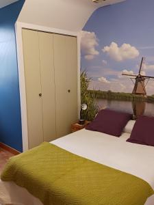 a bedroom with a bed with a view of a windmill at chambres d'hôtes du clos du roi in Pontorson
