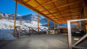 a covered porch with a view of a snowy mountain at Apache Eco Camp, Terelj Nationalpark Mongolia in Bayan Bulagiin Hural