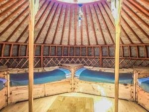 a large wooden bed in a large wooden tent at Apache Eco Camp, Terelj Nationalpark Mongolia in Yoliin Hural