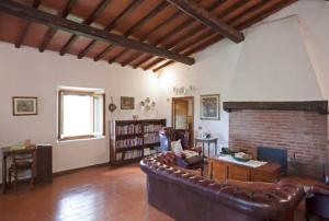 - un salon avec un canapé et une cheminée en briques dans l'établissement La Favilletta Casa Vacanze, à Torri