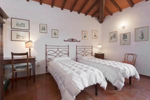 - une chambre avec 2 lits, une table et un bureau dans l'établissement La Favilletta Casa Vacanze, à Torri