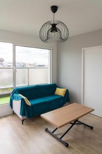 a living room with a blue couch and a table at F2 HyperCentre Clermont Ferrand in Clermont-Ferrand