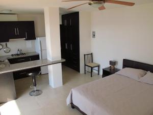 a bedroom with a bed and a kitchen with a table at Los Sonidos de las Olas in Santa Marianita