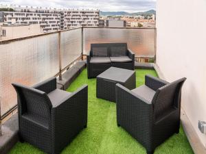 een balkon met stoelen en een tafel en gras bij F2 HyperCentre Clermont Ferrand in Clermont-Ferrand