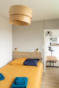 Un dormitorio con una gran cama amarilla y una gran lámpara de araña. en F2 HyperCentre Clermont Ferrand en Clermont-Ferrand