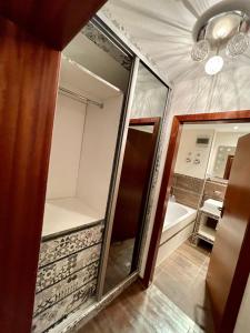 La salle de bains est pourvue d'un miroir et d'une baignoire. dans l'établissement Wunderschönes 2 Zimmer Apartment Zentrum Goldstadt, à Pforzheim