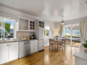 a kitchen with white cabinets and a table with chairs at 1 An tSean Scoil, Clifden in Clifden