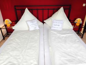 2 Betten mit weißen Kissen mit den Worten Liebe in der Unterkunft Villa Sonnenterrasse in Pelzerhaken