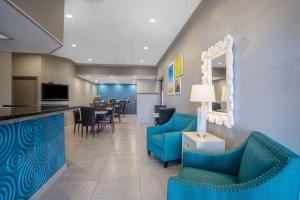 a hotel lobby with blue chairs and a bar at Days Inn by Wyndham Lonoke in Lonoke
