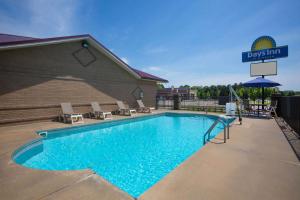 een zwembad met stoelen en een basketbalring bij Days Inn by Wyndham Lonoke in Lonoke