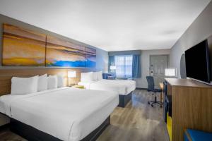 a hotel room with two beds and a desk at Days Inn by Wyndham Lonoke in Lonoke +37 photos